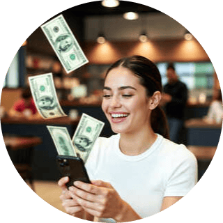 girl in coffee shop with dollar bills floating out of her mobile phone